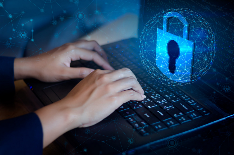 Hands typing on a keyboard with a digital padlock symbolizing cybersecurity.