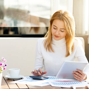 Businesswoman analyzing charts and data on a tablet, deciding on a location for her business in Dubai.